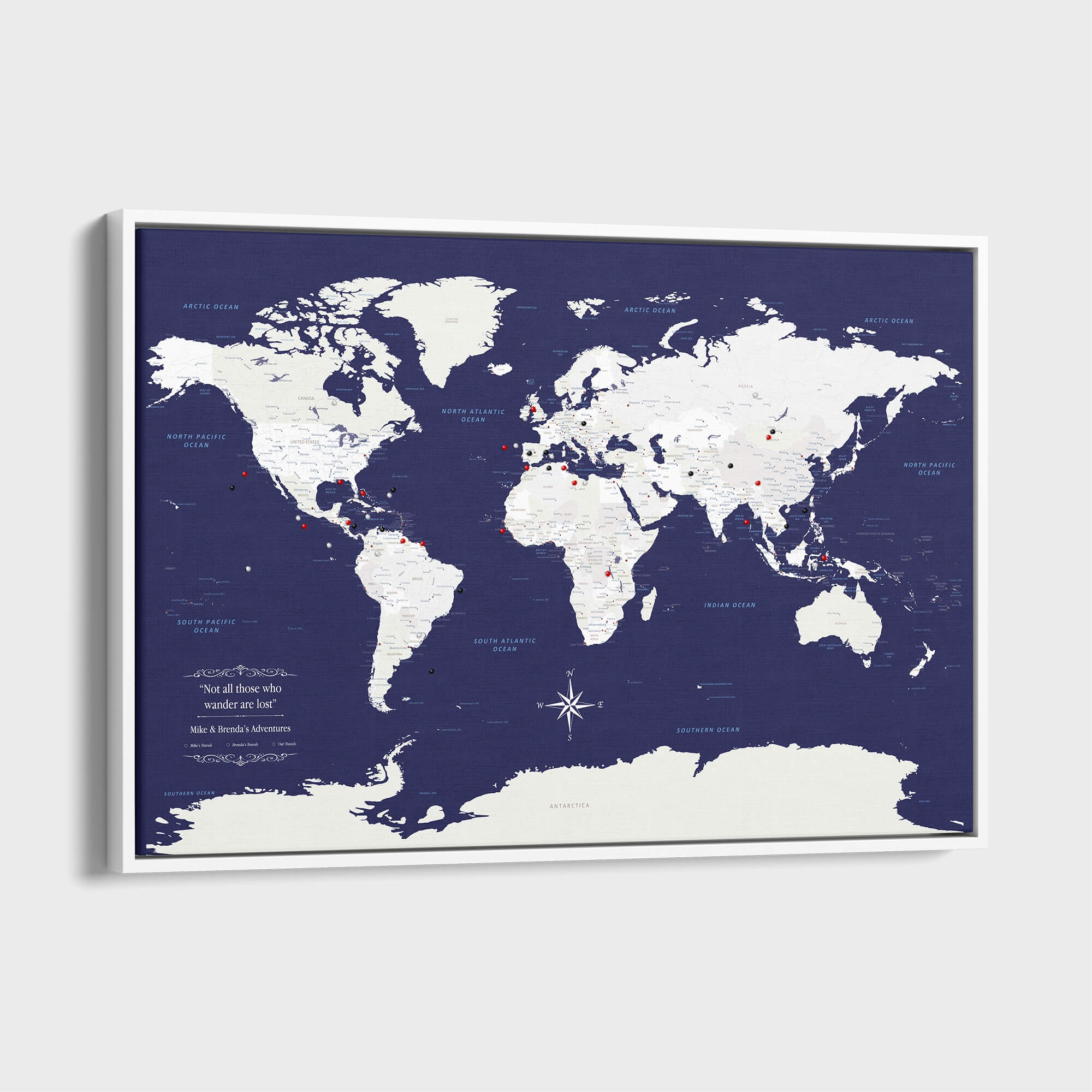 Navy Explorers world travel map canvas with push pins in white frame mounted on wall