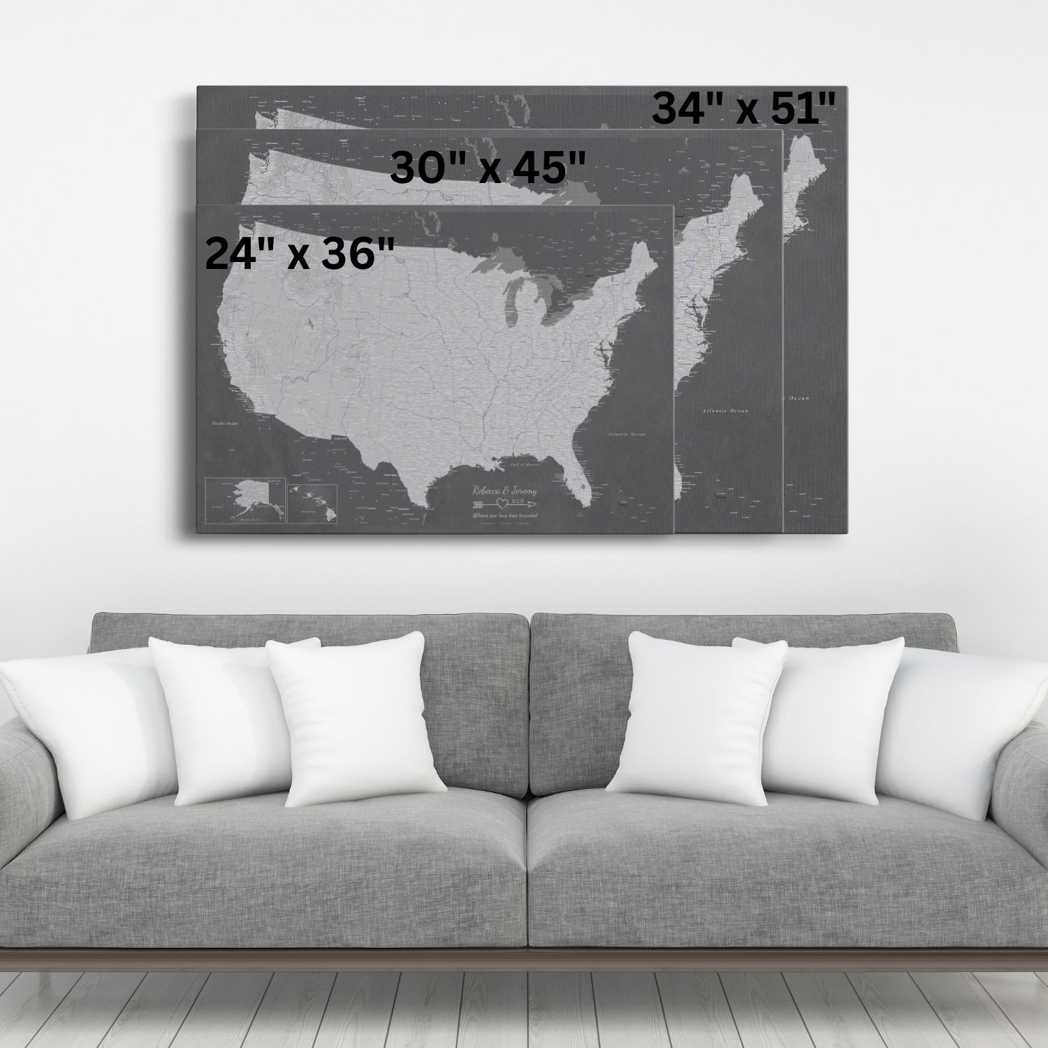 Three size comparison views of grey charcoal USA travel pin map canvas hung above modern sofa