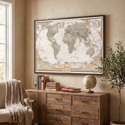 Framed National Geographic executive world travel map with pins displayed above mid-century modern wooden console in cozy living room