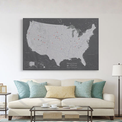 Stormy Dreams USA travel map with pins displayed above living room sofa on white wall