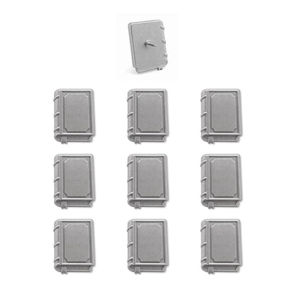 Set of nine silver book-shaped push pins with one showing pin backing on white background