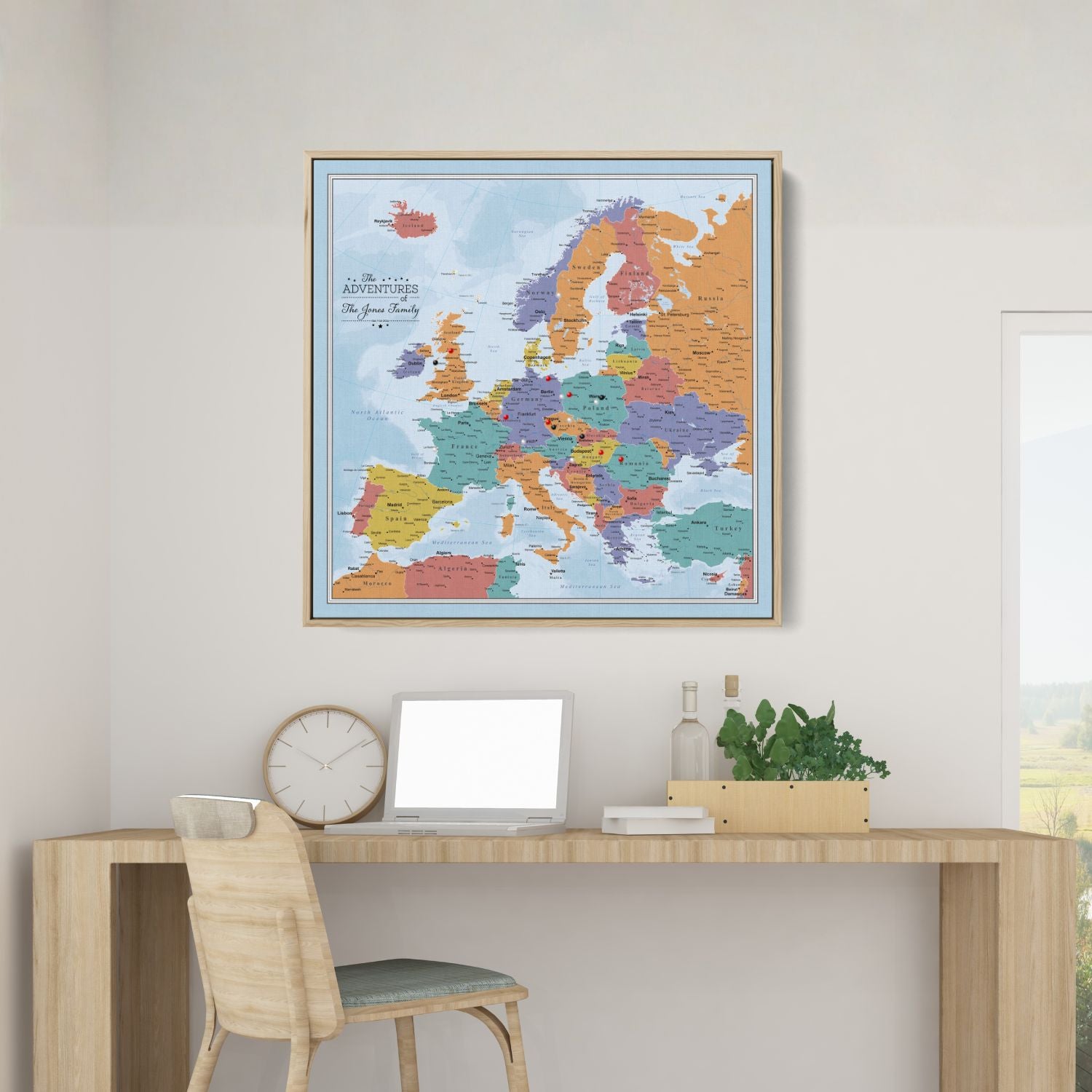 Personalized Blue Oceans Europe travel map with pins in natural wood frame displayed above modern desk