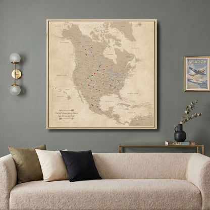 Vintage North America travel map canvas with red and black pins displayed above modern living room sofa