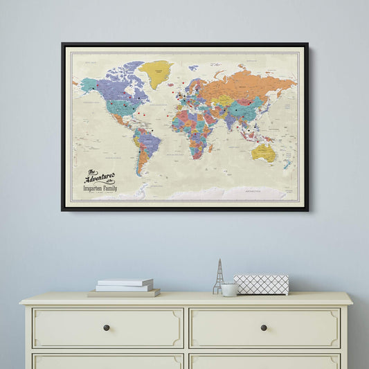 Personalized canvas tan ocean world travel map with pins in black frame hung above cream dresser